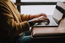 A person sitting in front of an open laptop computer