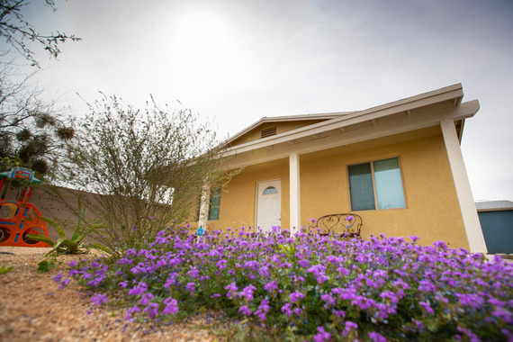 yellow house with purple flowers