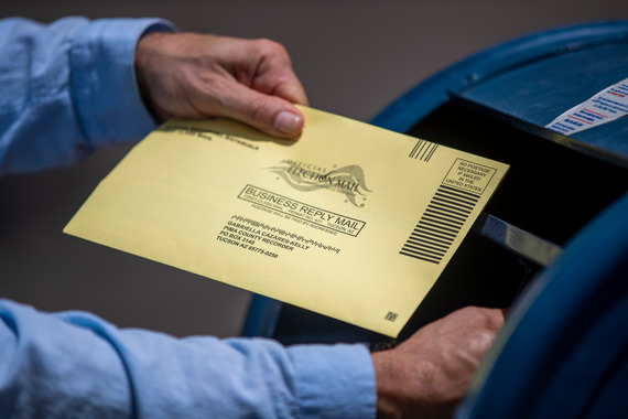 Man dropping a ballot into a mailbox