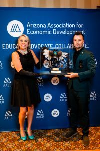 Economic Development Director Heath Vescovi-Chiordi stand with Jenn Lindley of Queen Creek. They are holding a kachina in a glass box