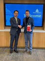Economic Development Director Heath Vescovi-Chiordi shakes the hand of a man from Taiwan