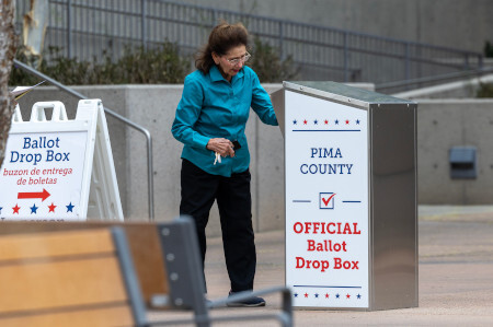 woman dropping off her ballot