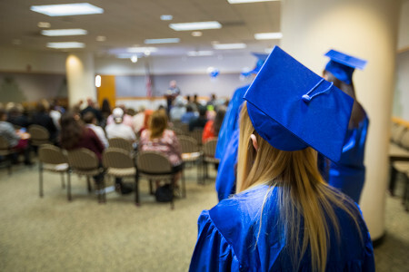 girl with graduation cap in library