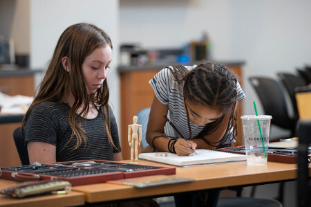Two kids drawing at the library