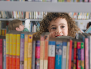 child looking through bookcase