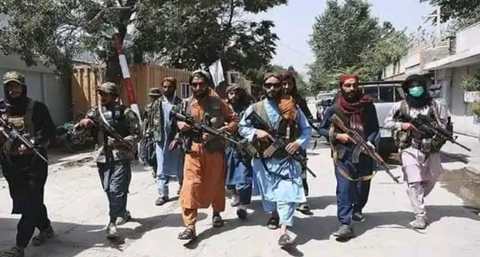 Taliban walking in line formation with AK's in hand
