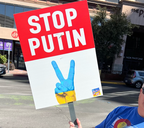 Someone holding a poster board that says "STOP PUTIN"