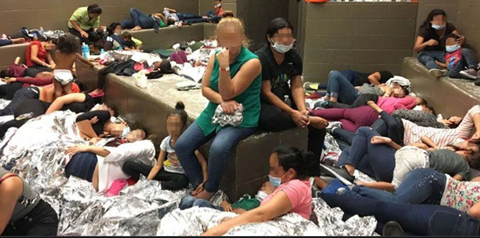 Picture of many refugees inside a room laying on floor