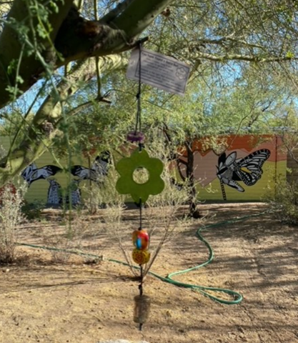 Picture of secret Bells hanging in the tree with mural background