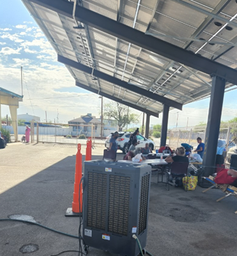 Picture showing people stay in the parking area and being cooled by the evaporative cooler