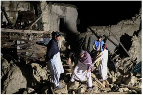 Picture showing some Afghans standing on the top of the debris after the earthquake