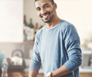 Man smiling while preparing food in his home