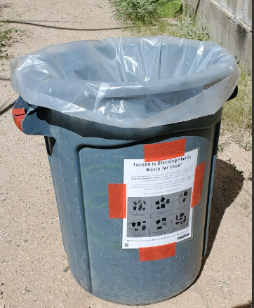 Picture shows trash bin with plastic pilot program information 