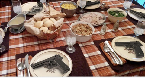 Picture shows Thanksgiving table setting with weapon on the plates 