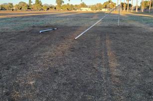 Picture of Himmel Park showing tires marks and the broken soccer posts left on the field