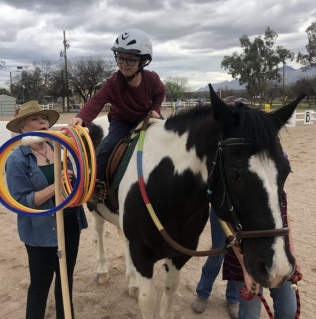 Picture shows a kid conducts the therapy while riding the horse