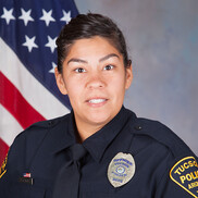 TPD ODE Officer Christina Garcia in uniform in front of an American flag