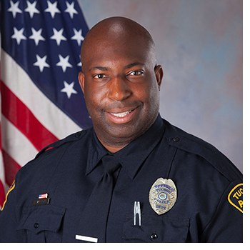 TPD Officer Richard Valentine in uniform in front of an American flag