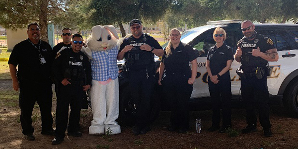 ODM members, in uniform stand in a line for a group photo under trees and with the Easter Bunny