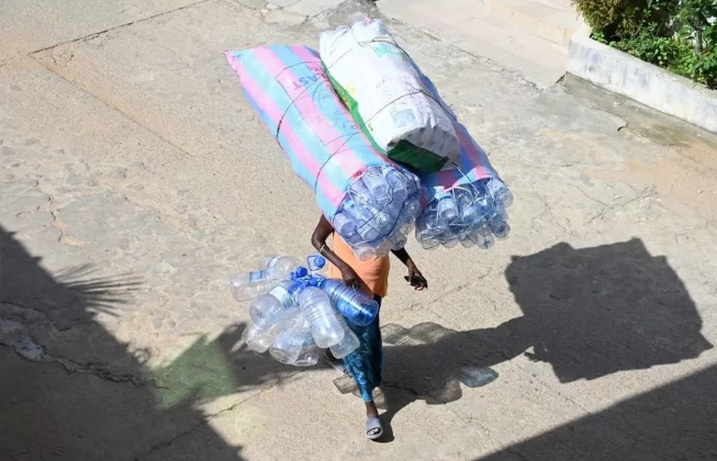 A woman in the Ivory Coast carrying her plastic to market