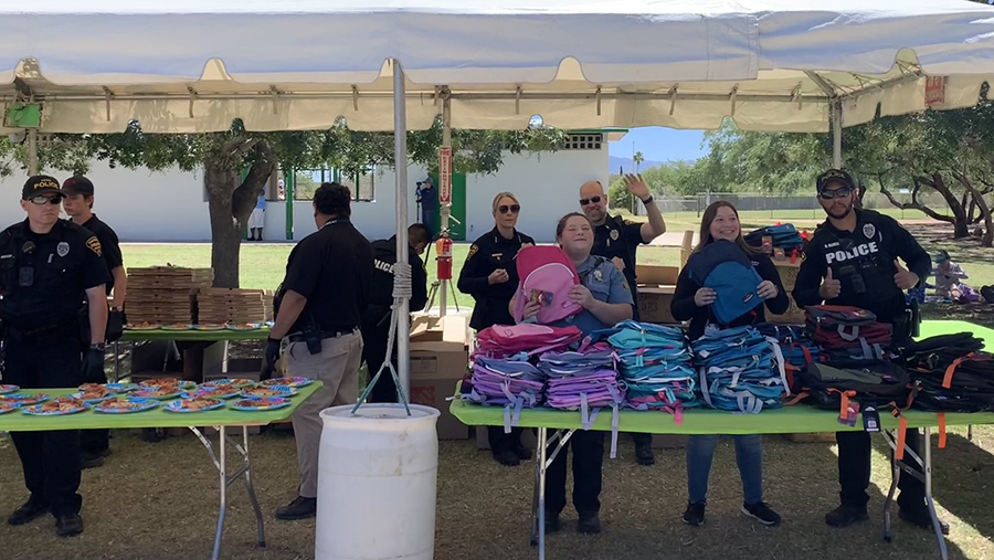 TPD ODE members in uniform outside under a white tent with tables.