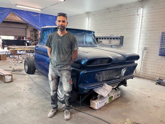 Photo of Issac working on a truck in his shop.