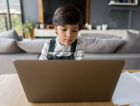 Picture of a kid watches a video on laptop 