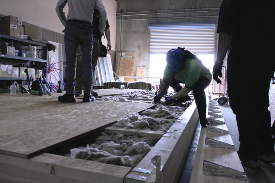 Photo of construction workers building a platform for a tiny home.