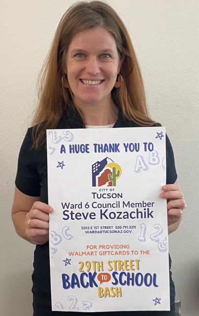 Picture of Laura Lopez from HCD holds the appreciation flyer to CM Kozachik