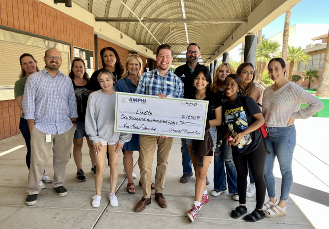 Photo of Tim Kromer holding a giant check along with his team at the Amphi Foundation.
