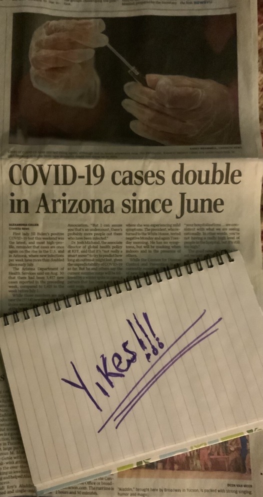 photo of newspaper page that shows COVID cases on the rise