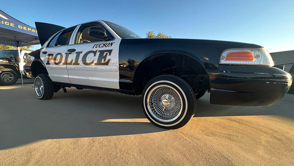 A close-up elongated photo of TPD's lowrider vehicle outdoors at an event.