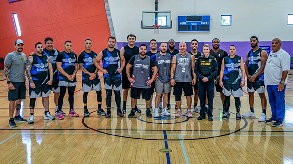 Group photo of TPD basketball players indoors at a gym.