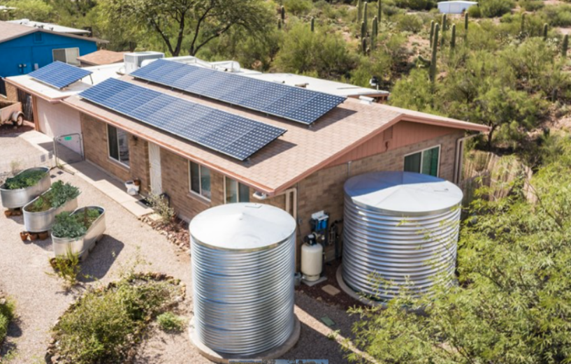 Picture of a house with solar panels and water harvesting system built in