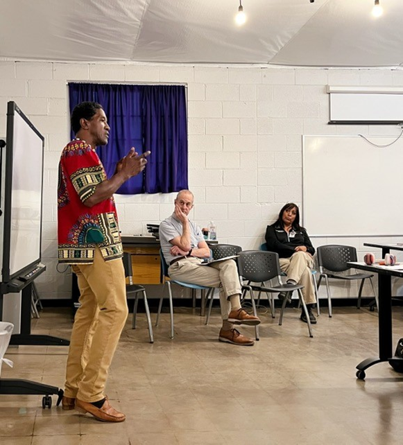 Photo of Hassan Clement kicking off the info session with Alan R. Soto and Colleen Bigman waiting for their turn to present. 
