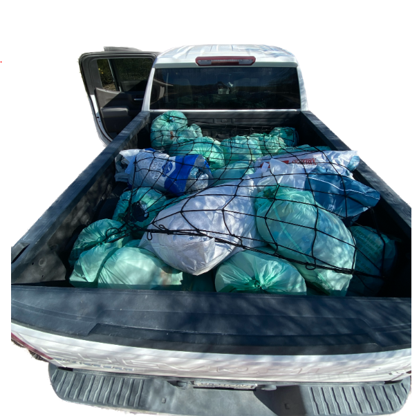 A white truck bed full of plastic bags for recycling 