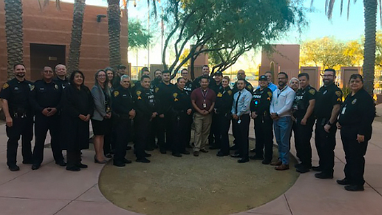 TPD and Pascua Yaqui members line up outside in the shade for a group shot.
