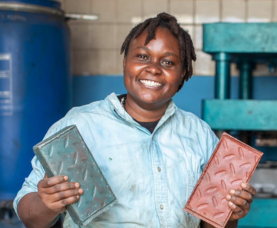 Picture of Nzambi holding up bricks