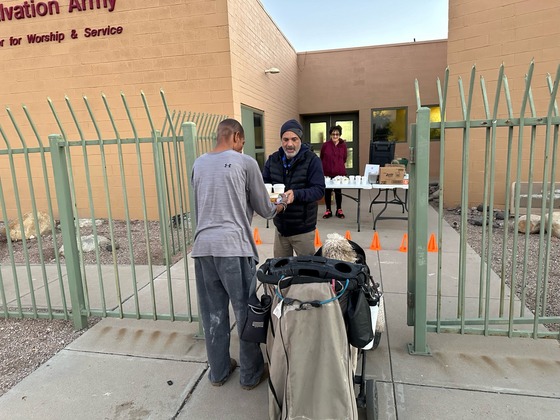 Photo of Shawn Milligan helping serve and unhoused man.