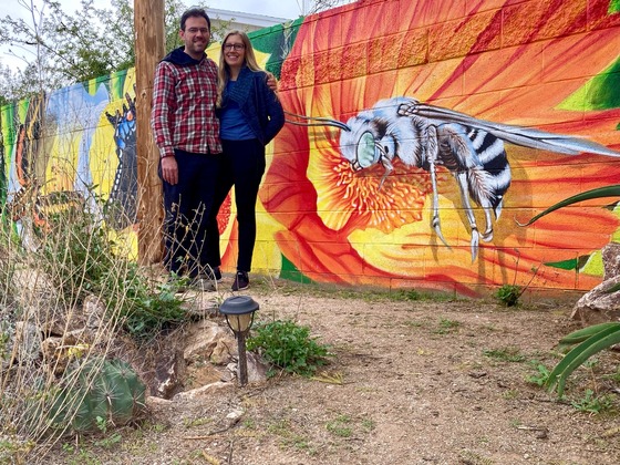 Photo of Michael Heily and Erin Heily in front of the mural they commissioned Ignacio Garcia to paint.
