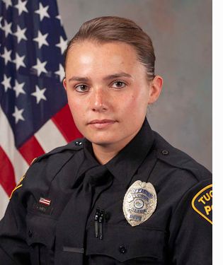 Department photo of female TPD Officer in uniform in front of an American flag.