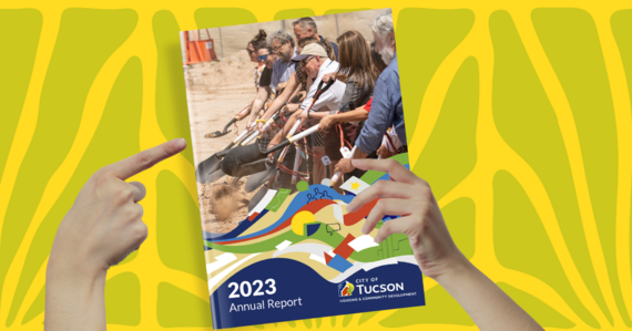 Hands holding and pointing at the HCD Annual Report Cover