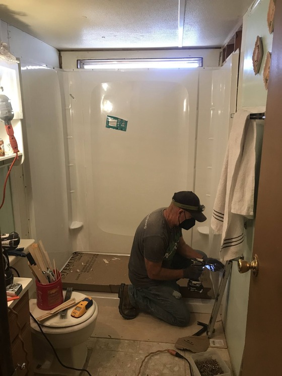 Photo of CHRPA Volunteer installing a shower pan.