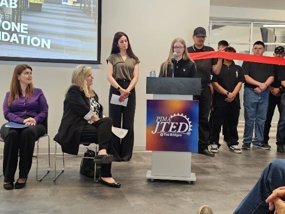 Picture of Mayor Romero and JTED CEO Kathy Prather listening to student speakers at the lectern.