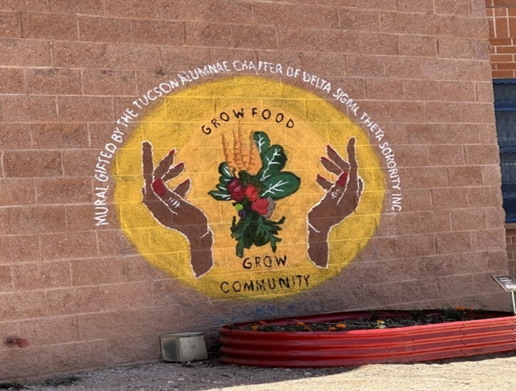 Utterback Middle School's Community Garden Sign.  Two hands surrounding an image of vegetables and the words Grow Food, Grow Community