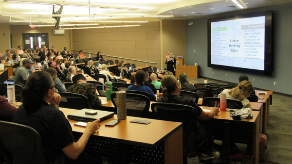 Full auditorium/training room attend a PowerPoint presentation on human trafficking.