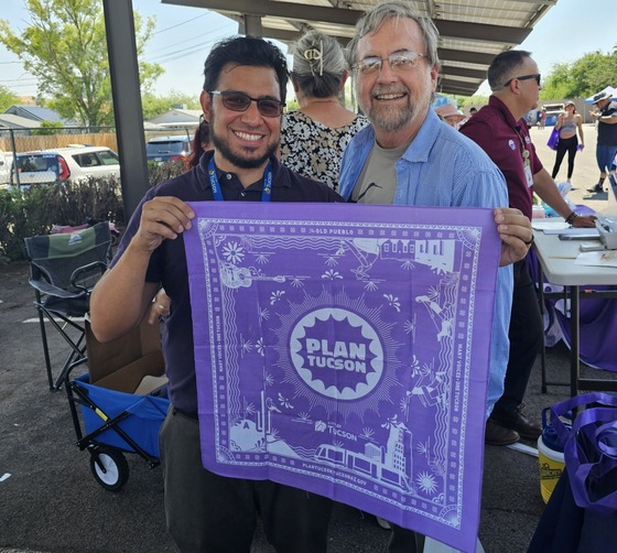 Photo of Cesar Acosta and Vice Mayor Kevin Dahl holding up a bandana with the plan Tucson logo on it.