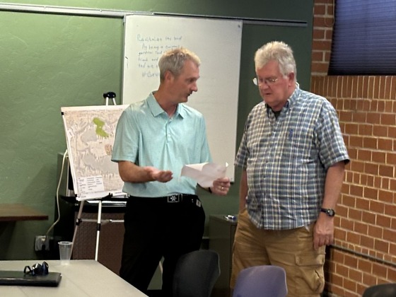 Photo of Parks and rec official talking to a constituent about the new park design.