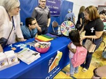 Photo of Ward 5 Backpack Event - Kids getting backpacks and playing a spin the wheel prize game