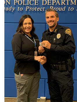 TPD Chief Kasmar presents a pin to a Community Service Officer in plainclothes.